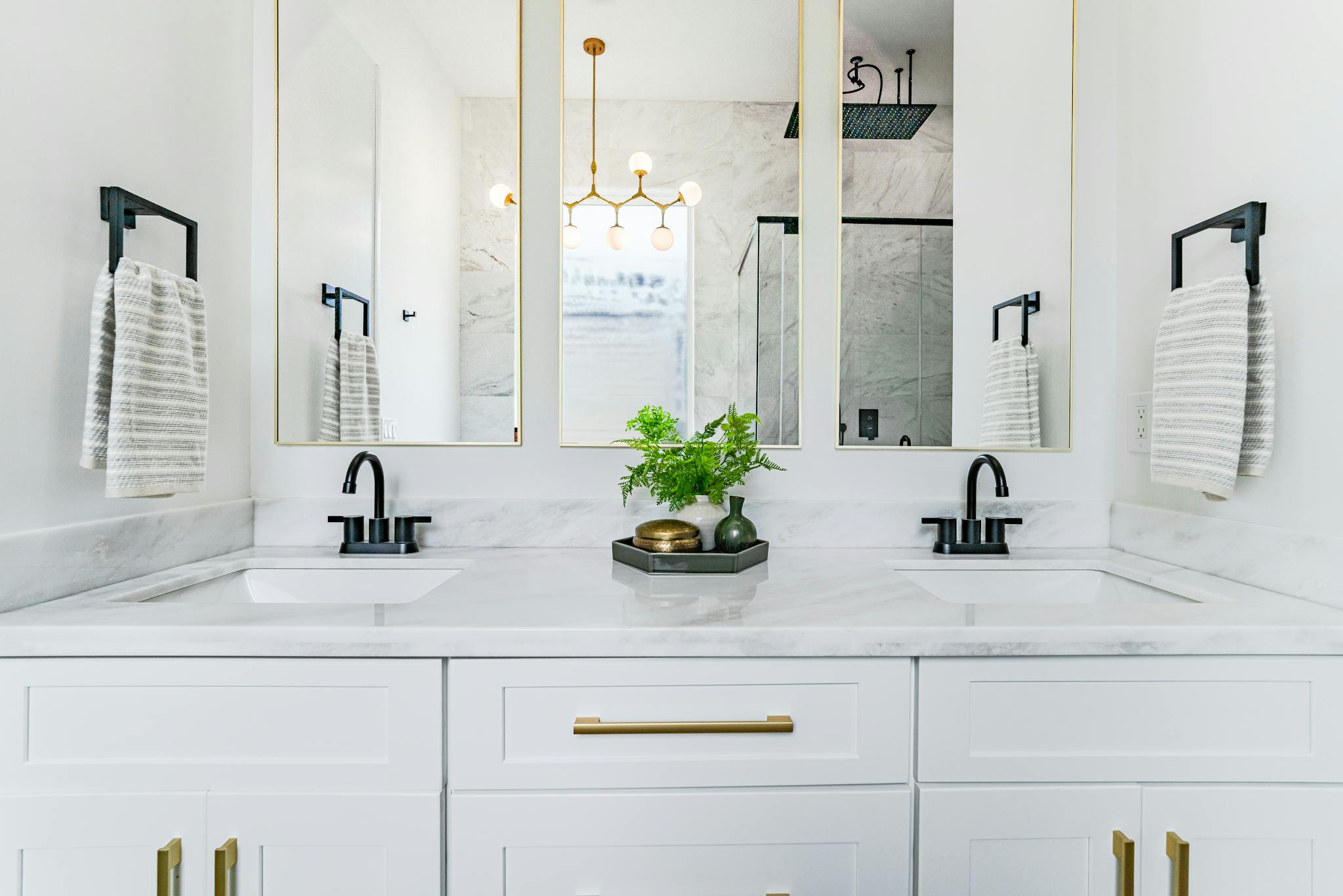 Bright, elegant bathroom interior with double sinks, mirrors, and modern lighting in New Orleans.